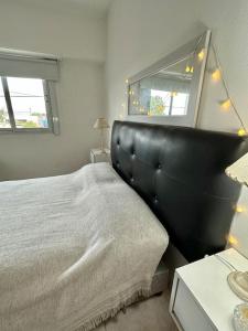 sypialnia z dużym łóżkiem z zagłówkiem z czarnej skóry w obiekcie Hermoso Moderno Depto c/cochera w mieście Olavarría