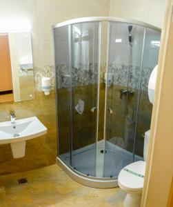 ein Bad mit einer Dusche, einem WC und einem Waschbecken in der Unterkunft Little Orient in Brăila