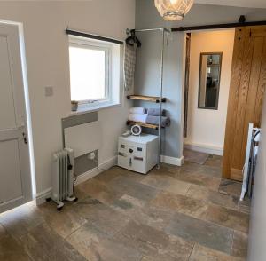 a room with a tile floor and a window and a radiator at Adorable bedsit for you, partner and your pet! in Pembrokeshire