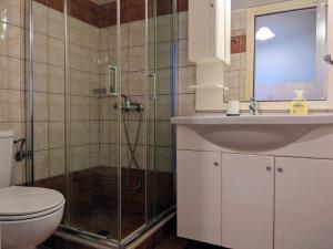 a bathroom with a shower and a toilet and a sink at Vikentios Rooms in Kýthira