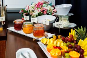 a buffet with jams and fruit on a table at Hotel Wyspiański in Krakow +111 photos