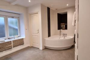 a large bathroom with a tub and a window at Dinard : loft de 175 m² - à 150 m de la plage in Dinard +10 photos