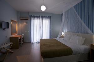 a hotel room with a bed and a window at Valente Perlia Rooms in Poros