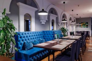 jadalnia z niebieską kanapą i stołami w obiekcie Hotel Wyspiański w Krakowie