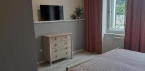 um quarto com uma cama e uma cómoda com uma televisão em Apartment 2 em Jindrichuv Hradec