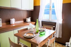 una pequeña cocina con una mesa de madera y una ventana en Villa Plinio Lago di Como, en Dervio