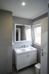 uma casa de banho com um lavatório branco e um espelho. em Apartments Choice em Velika Gorica