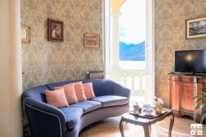 デルヴィオにあるVilla Plinio Lago di Comoのリビングルーム(青いソファ、テレビ付)