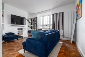 a living room with blue chairs and a tv at Central London apartment in Vauxhall near big Ben in London