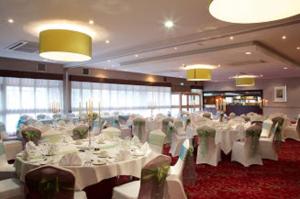 a large banquet hall with white tables and chairs at Stourport Manor Hotel in Stourport