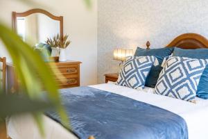 Un dormitorio con una cama con almohadas azules y blancas. en Casa da Tia Douro, en Peso da Régua