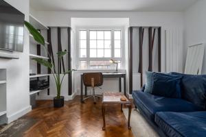 sala de estar con sofá azul y escritorio en Central London apartment in Vauxhall near big Ben, en Londres