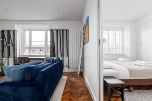 a living room with a bed and a blue couch at Central London apartment in Vauxhall near big Ben in London