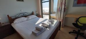 a bedroom with a bed with towels and a desk at Wonderful seaside residence in Monemvasia