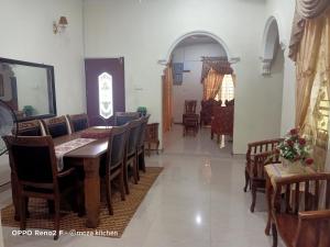 a dining room with a table and some chairs at McZa Homestay in Kota Bharu