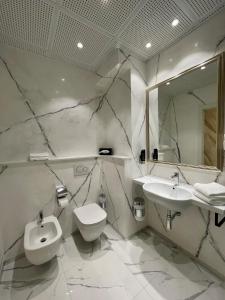 a bathroom with two sinks and a toilet and a mirror at Hotel Ristorante Continental in Osio Sotto
