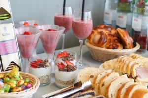 a table topped with desserts and drinks and baskets of bread at Pansion Leggero in Krk