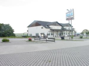 un bâtiment blanc avec un panneau devant lui dans l'établissement Hotel und Gasthaus Rammelburg-Blick, à Friesdorf
