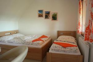 two twin beds in a bedroom with a chair at PENZION POD PALAVU in Šakvice