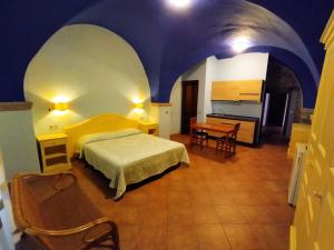 a bedroom with a bed and a table in a room at Sa Balza Guest House in Bosa