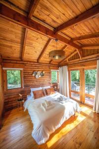 1 dormitorio con 1 cama grande en una habitación de madera en Lodge de Bellemene, en Bellemène