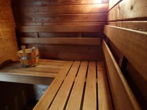 a wooden bench in a sauna with a bucket at Badhotel Renesse in Renesse