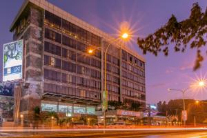 um edifício numa rua da cidade à noite em CBD Hotel em Dar es Salaam