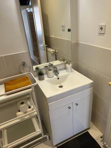 een badkamer met een witte wastafel en een spiegel bij New York Palace Apartment in the downtown in Boedapest