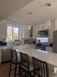 a kitchen with a large white counter and chairs at Park B&B in Oxon Hill