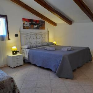 a bedroom with a large bed with a blue blanket at La Fortezza casa vacanze & appartament in Castelsardo
