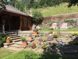 a garden with flowers in front of a cabin at Cosy Traditional Swiss Chalet in Wengen +20 photos