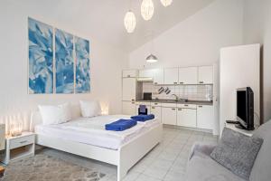 a white bedroom with a large bed and a kitchen at Fewo Eg Links - Hunde erlaubt in Oberteuringen