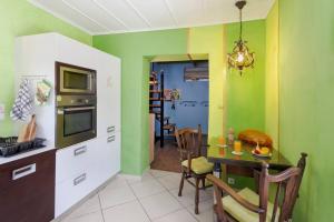eine Küche mit grünen Wänden, einem Tisch und einem Esszimmer in der Unterkunft Ioli's Home - Medieval Town in Rhodos (Stadt) + 28 Fotos