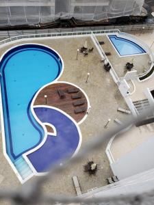 an overhead view of two large swimming pools at Apartamento confortável no Centro in Bertioga +26 photos