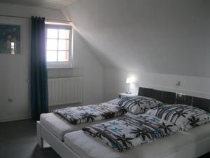 een slaapkamer met 2 bedden en een raam bij Ferienwohnung Haus Sofi in Überlingen