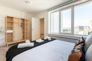 a bedroom with a large bed and a large window at Sweet Inn - De Brouckere in Brussels