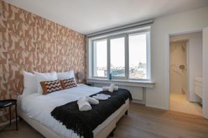 um quarto com uma cama e uma grande janela em Sweet Inn - De Brouckere em Bruxelas