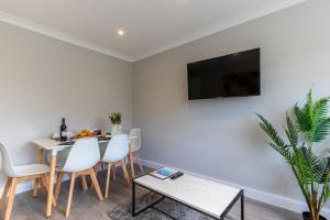 a dining room with a table and a tv on a wall at Altham Place-Free Parking Space in Morecambe