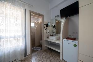 Livadi AstypalaiasにあるGiasemi Room No 5 Astypaleaのバスルーム(洗面台、トイレ付)、テレビが備わります。