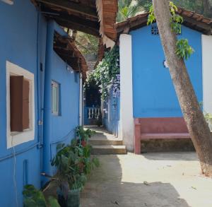 a building with blue walls and a bench on the side at Villa Khatun Guesthouse in Panaji