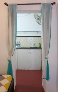 a room with a window with blue curtains at Villa Khatun Guesthouse in Panaji