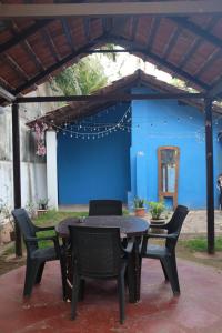 a patio with a table and chairs and a blue wall at Villa Khatun Guesthouse - Peaceful Boutique Guesthouse near Fontainhas in Panjim in Panaji