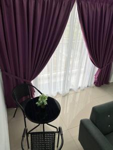 a table and a chair in front of a window at 92D’venus Residence in Sitiawan