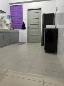 a kitchen with a purple door and a white floor at 92D’venus Residence in Sitiawan