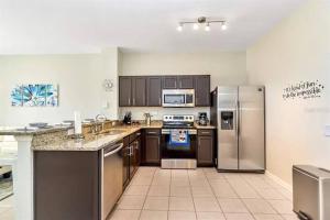 una cocina con nevera y electrodomésticos de acero inoxidable en Minutes to Disney, Free Water Park & Private Pool, en Orlando