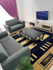 a living room with two couches and a tv at 92D’venus Residence in Sitiawan