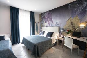 - une chambre avec 2 lits et un bureau dans l'établissement Hotel Sirio, à Lido di Camaiore