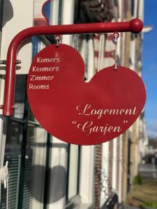 un panneau en forme de cœur suspendu du côté d'un bâtiment dans l'établissement Logement Garjen, à Harlingen