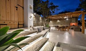 een patio met banken en een tafel en stoelen bij Villa Mykonos Heaven - Sea View & Outdoor Hot Tub in Mykonos-stad