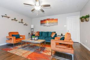 uma sala de estar com um sofá azul e duas cadeiras em IDYLLIC LAKEVIEW HOME em Spring